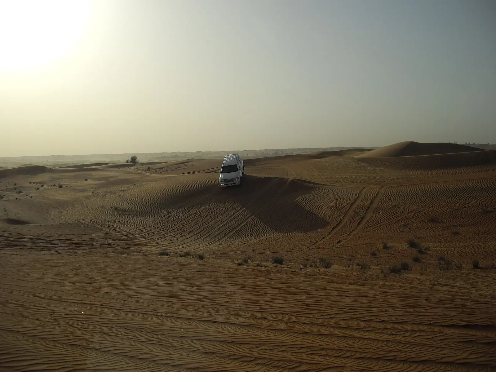 Vehicles on the red dunes of the desert outside Dubai