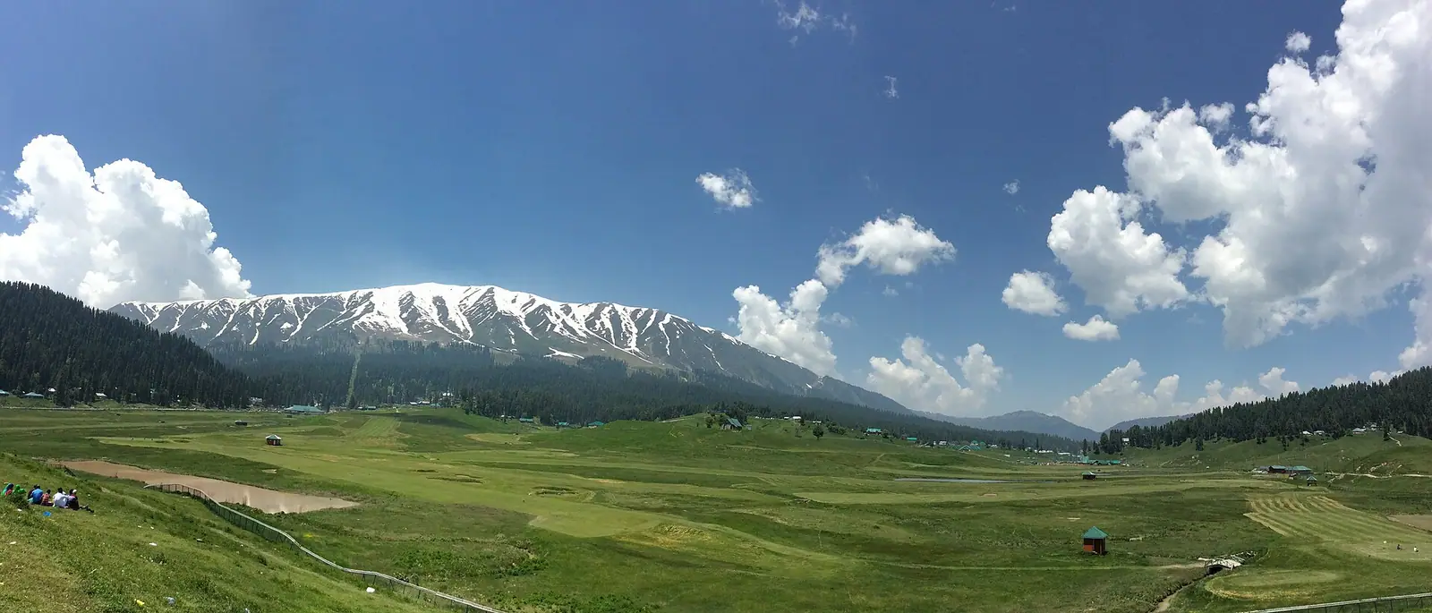 The open snow-covered meadow of Gulmarg ringed by fir forest in Kashmir
