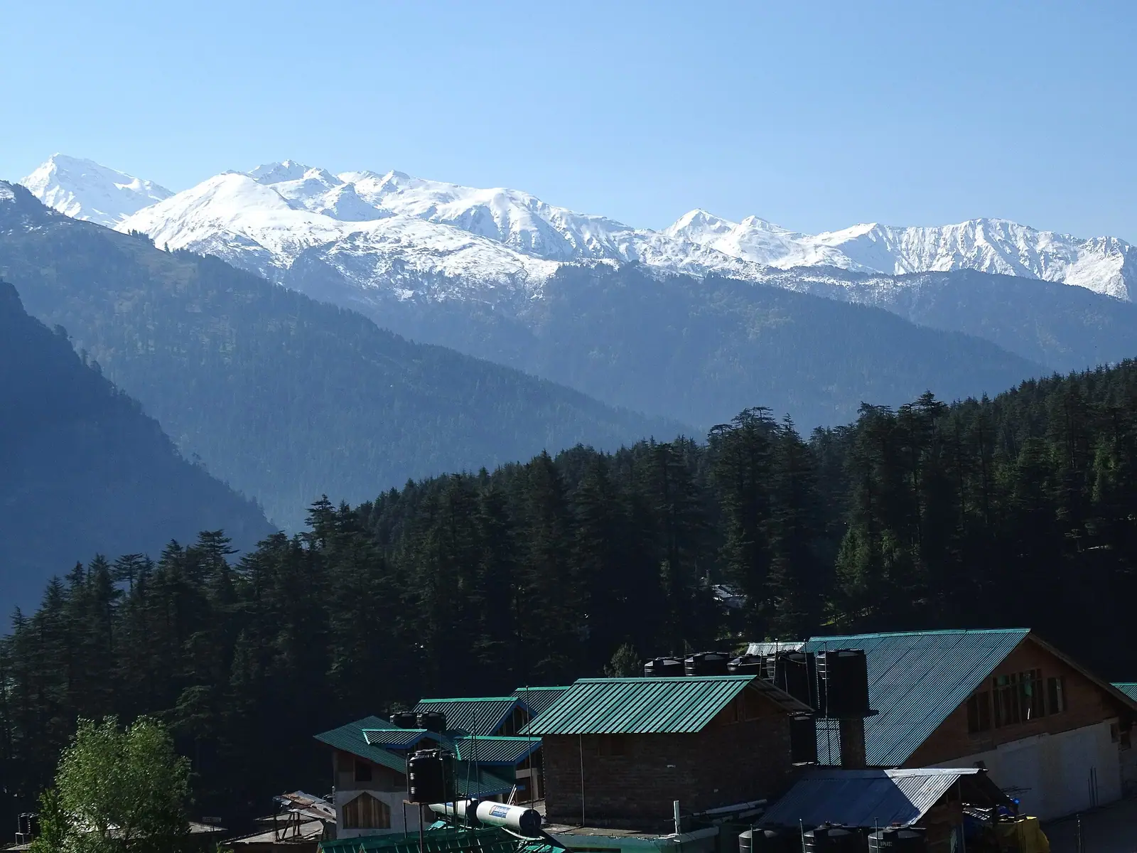 Slate-roofed houses and orchards of Old Manali on the hillside above the Kullu valley